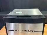 a silver and black oven sitting on top of a wooden table