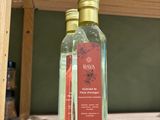 a bottle of water sitting on a shelf next to a bottle of liquid