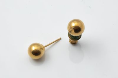 a pair of gold ball stud earrings on a white surface
