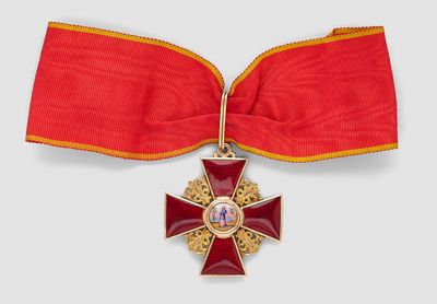 une image représentant un ruban rouge orné d'une croix dorée