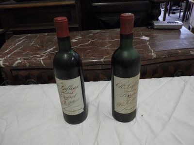 two bottles of wine sitting on a table next to each other