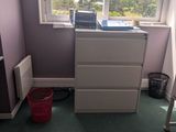 a dresser in the corner of a room with a window