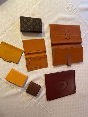 several pieces of louis vuitton wallets on a white surface