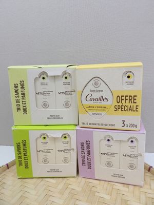 three boxes of earphones sitting on top of a bamboo mat