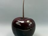 une pomme rouge avec une tige qui en sort