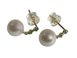 une paire de boucles d'oreilles en perles et émeraudes sur fond blanc