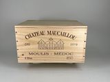 La boîte en bois, posée sur une table, contient une bouteille de vin.