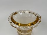 a clear glass vase with a gold rim on a white surface