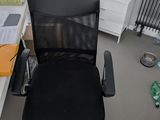 a black office chair sitting in the corner of a room