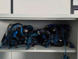 a shelf with a bunch of headphones and wires on it