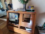 two televisions sitting on a wooden stand in a living room
