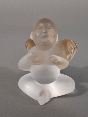 une figurine en verre représentant un bébé assis par terre