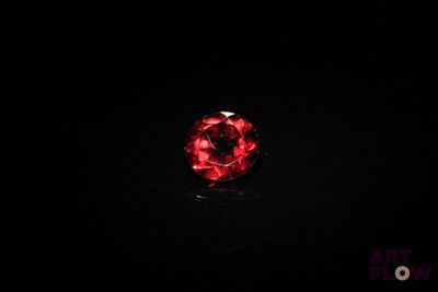 a close up of a red stone on a black surface