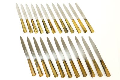 eight knives are lined up in a row on a white surface