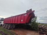 un camion-benne rouge garé sur le bord de la route