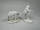 two figurines of a man riding a horse and a cow
