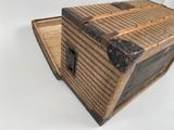 a small wooden box with a lid on a white surface