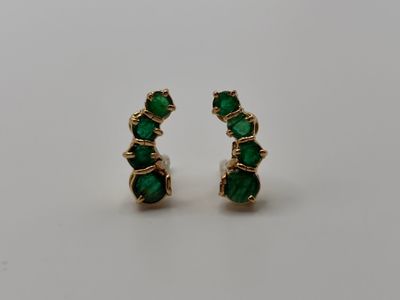 a pair of emerald earrings on a white background