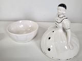 a small figurine of a boy sitting on top of a bowl