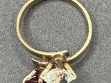 an image of a gold ring with a garnett and a diamond
