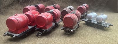 several red barrels are lined up on top of a train car