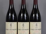 three bottles of wine are lined up on a table