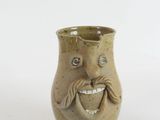 a ceramic vase with a face and a mustache on it