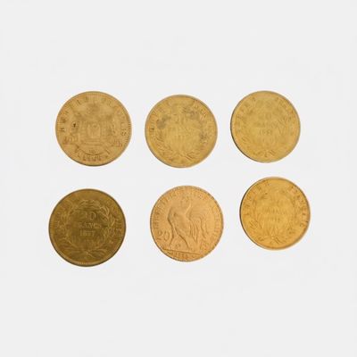 four gold coins are arranged in a row on a white surface