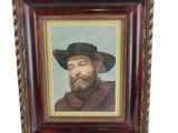 portrait d'un homme barbu coiffé d'un chapeau noir, dans un cadre en bois