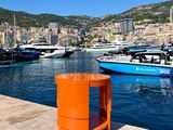 de nombreux bateaux à l'eau près d'un quai où se trouve une poubelle orange