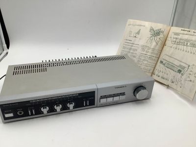 une image représentant un poste de radio posé sur une table, à côté d'un livre ouvert