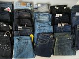many pairs of jeans that are stacked together on a table