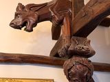 a wooden sculpture of a dragon hanging on a wall