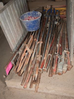 a pile of wooden sticks and a bucket on the ground