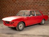 a red car that is parked in front of a brick wall
