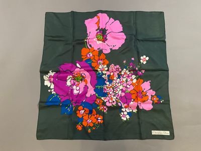 a close up of a green scarf with flowers on it