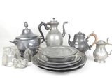 a lot of silver dishes and cups on the table