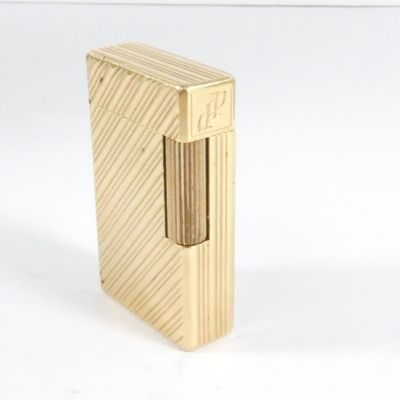 un briquet doré posé sur une surface blanche
