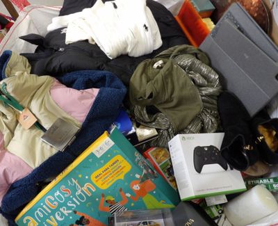 a pile of clothes and books on a bed
