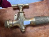 a brass faucet that is attached to a wooden table