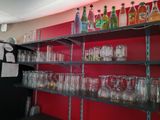 des bouteilles et des verres posés sur une étagère dans une pièce aux murs rouges