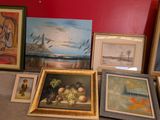 a lot of framed pictures and paintings on the table