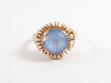 gros plan d'une bague en or avec une pierre bleue