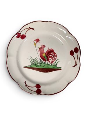 une assiette sur laquelle est peint un coq sur fond blanc