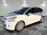 la petite voiture blanche est garée dans une pièce au sol à carreaux