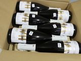 six bouteilles de vin se trouvent dans une boîte en carton sur laquelle est apposée une étiquette de prix