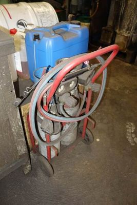 a cart with a hose and a can of water next to it