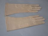 pair of beige leather gloves on a blue surface