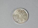 a silver coin with a picture on it on a table