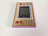 a pink and gold gameboy sitting on a white surface